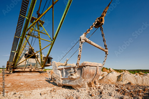 Bucket of old walking excavator digging calx in quarry photo