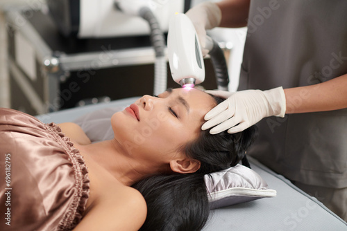 Woman getting forehead hair removal with alexandrite laser photo