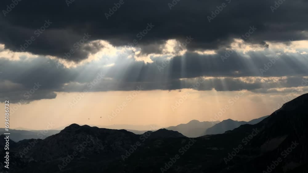 Timelapse of the sun's rays breaking through the clouds over the mountains of Durmitor.