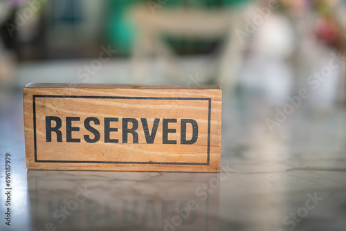 A wooden reserved sign that placed on the dining table at the luxury restaurant for booking the seat. Sign and symbol object photo.