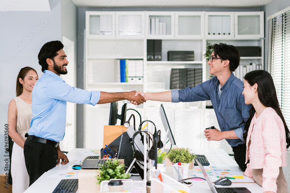 Cheerful Asian businessman partners handshaking with a smile as a symbol of teamwork. Positive multi-ethnic business colleagues on diversity in the office. Collaboration concept. Cheerful Asian businessman partners handshaking with a smile as a symbol of teamwork. Positive multi-ethnic business colleagues on diversity in the office. Collaboration concept.