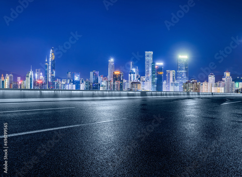 Asphalt road and modern city buildings at night in Shenzhen, China.