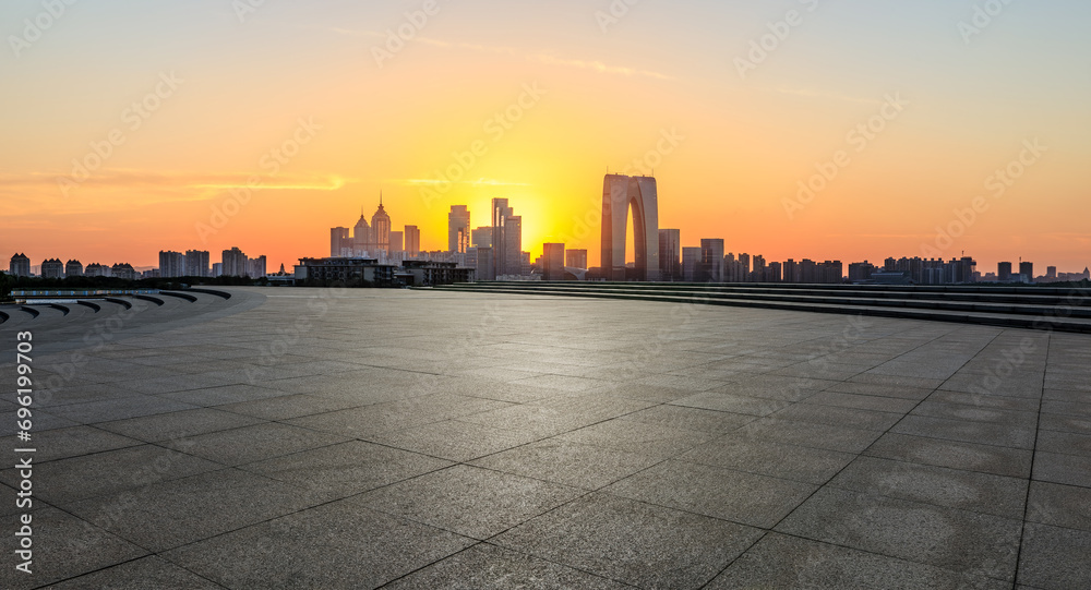 City square and skyline with modern buildings at sunset in Suzhou, China. Panoramic view.