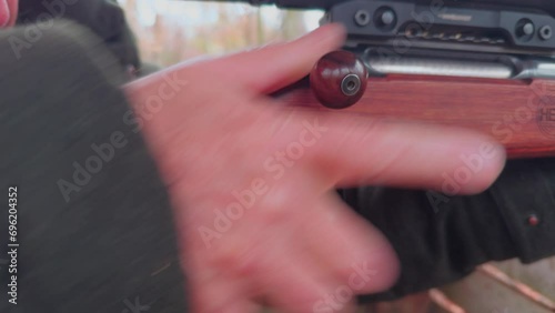 Close-up, the hand of a hunter loads a hunting rifle. photo