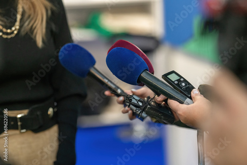 A poised group of journalists with microphones and cameras ready to delve into the heart of an event.