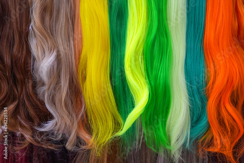 Hair samples of different colors palette. Different hair bright rich tint colors - yellow, green, crimson, orange. Various hair colors set background close up view. Extension equipment of natural.