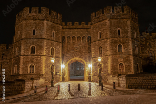 King Henry VIII gate private entrance secure stone fortified walls. Windsor Castle grounds lit at night. historic building in UK England royal home tourist attraction place of interest