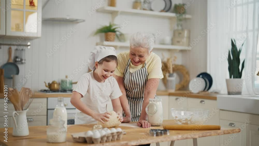 Granny granddaughter cooking at home. Family senior grandmother teaching child girl kneading dough on table, baking together on kitchen. Cooking culinary cuisine bakery preparing food bake concept.