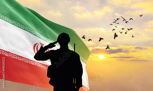 Silhouette of a soldier with the Iran flag stands against the background of a sunset or sunrise. Concept of national holidays. Commemoration Day. photo