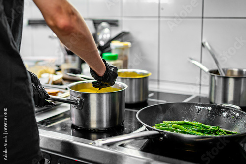 Chef hands cooking cheese sauce in the restaurant kitchen