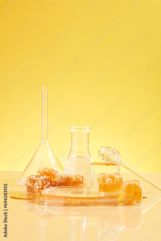 Natural raw beeswax is displayed alongside laboratory glassware. Concept of research and development of skin care products from honey. Front view. Natural raw beeswax is displayed alongside laboratory glassware. Concept of research and development of skin care products from honey. Front view.