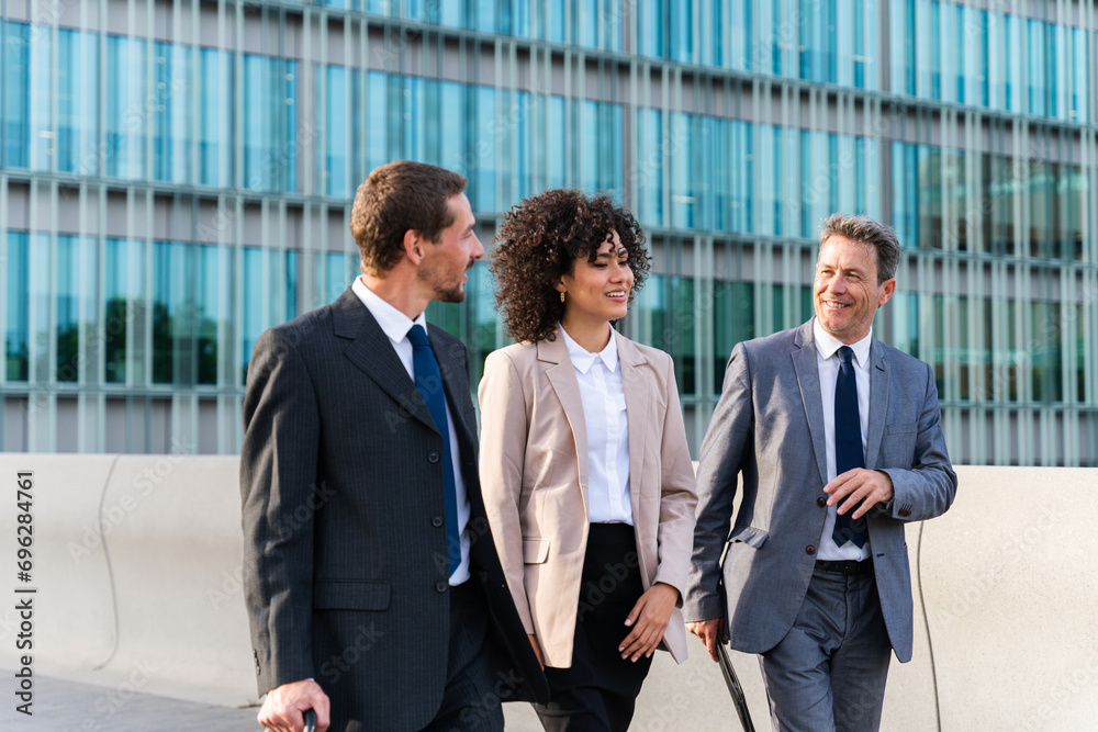 Business people meeting in a business park - Corporate businessmen and businesswoman bonding outdoors, colleagues meeting after work Business people meeting in a business park - Corporate businessmen and businesswoman bonding outdoors, colleagues meeting after work