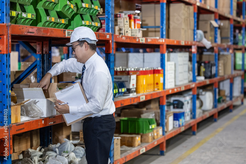 Warehouse manager process paperwork, organize goods by size, shape, category, prepare delivery date