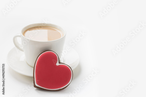 Cup of coffee with red glazed cookie as heart for breakfast on white background. Valentine's card. Love concept. Close up.