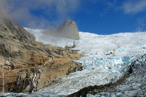  a steep rock spire in the sermeq glacier at the end of the tasermuit fjord on a sunny summer day near nanortalik, in southern greenland photo