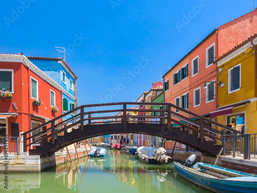 Bridge over a channel in town surrounded by colourful buildings (Burano, Italy)