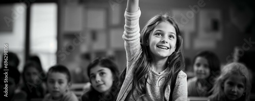une élève lève la main en classe pour demander la parole, photo noir et blanc format panoramique