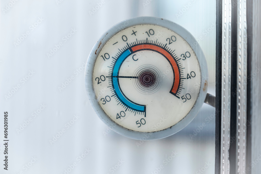 Circular old outdoor thermometer with minus 20 degrees celsius hangs on the outside of the window Circular old outdoor thermometer with minus 20 degrees celsius hangs on the outside of the window