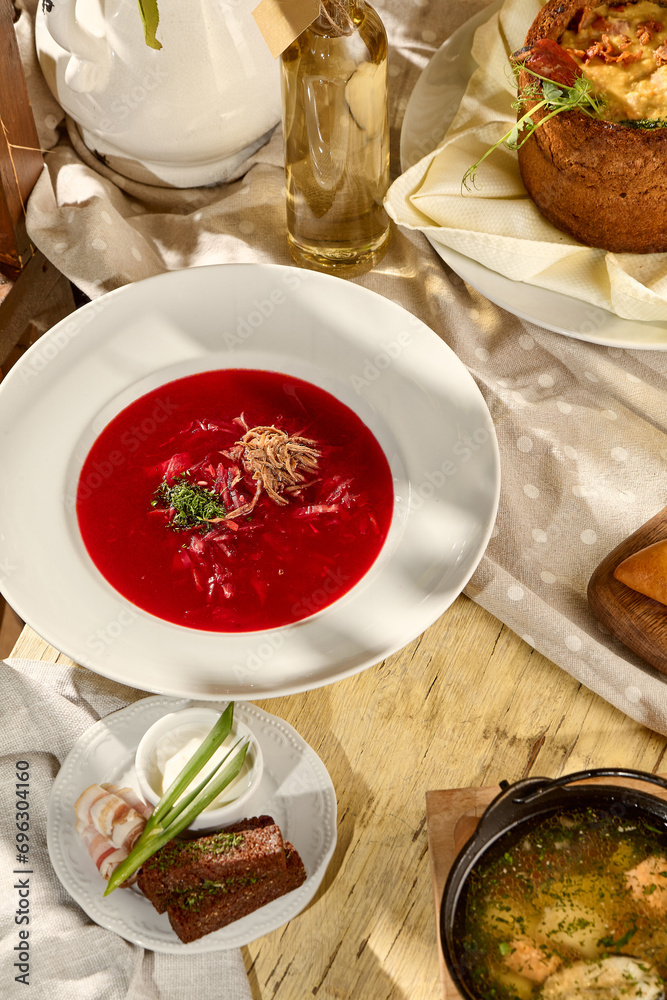 Borscht composition on a table with pork belly, garlic, and black bread, a Slavic dining staple Borscht composition on a table with pork belly, garlic, and black bread, a Slavic dining staple