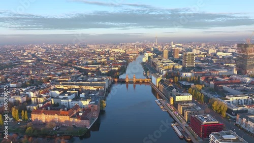 City of Berlin, Germany from above. Aerial cityscape view showing architectural landmarks Oberbaum Bridge, TV Tower and Berlin Cathedral at sunrise. Drone flight on the river Spree. photo