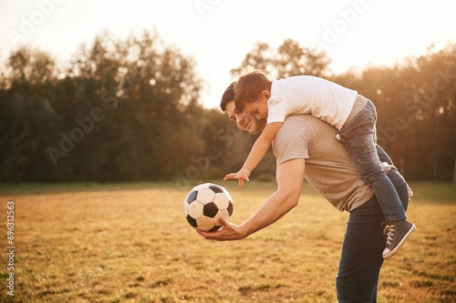 Soccer ball in hands. Father and little son are playing and having fun outdoors © standret