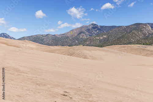 Hiking in the middle of the Great Sand Dunes with the Rocky Mountains in a distance