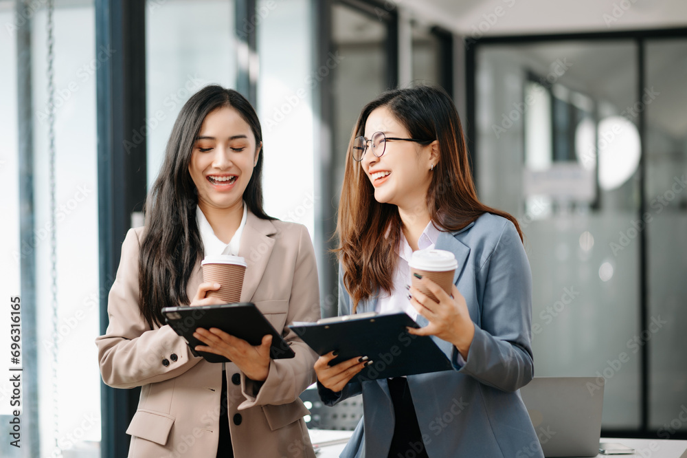 Happy businesspeople while collaborating on a new project in office. team of diverse business using a laptop and tablet in office. Happy businesspeople while collaborating on a new project in office. team of diverse business using a laptop and tablet in office.