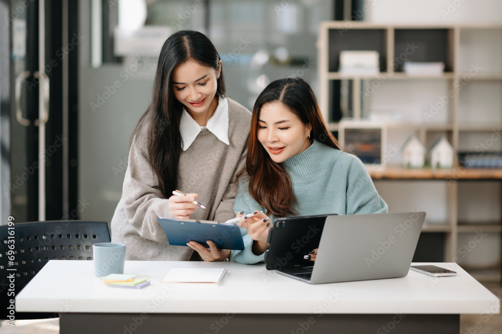 Happy businesspeople while collaborating on a new project in office. team of diverse business using a laptop and tablet in office. Happy businesspeople while collaborating on a new project in office. team of diverse business using a laptop and tablet in office.