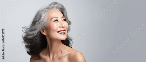 Korean woman face with smooth healthy neckline skin. Korean, Chinese asian Beautiful aging years old, young looking smiling woman, beauty health skincare and cosmetics advertising concept photo