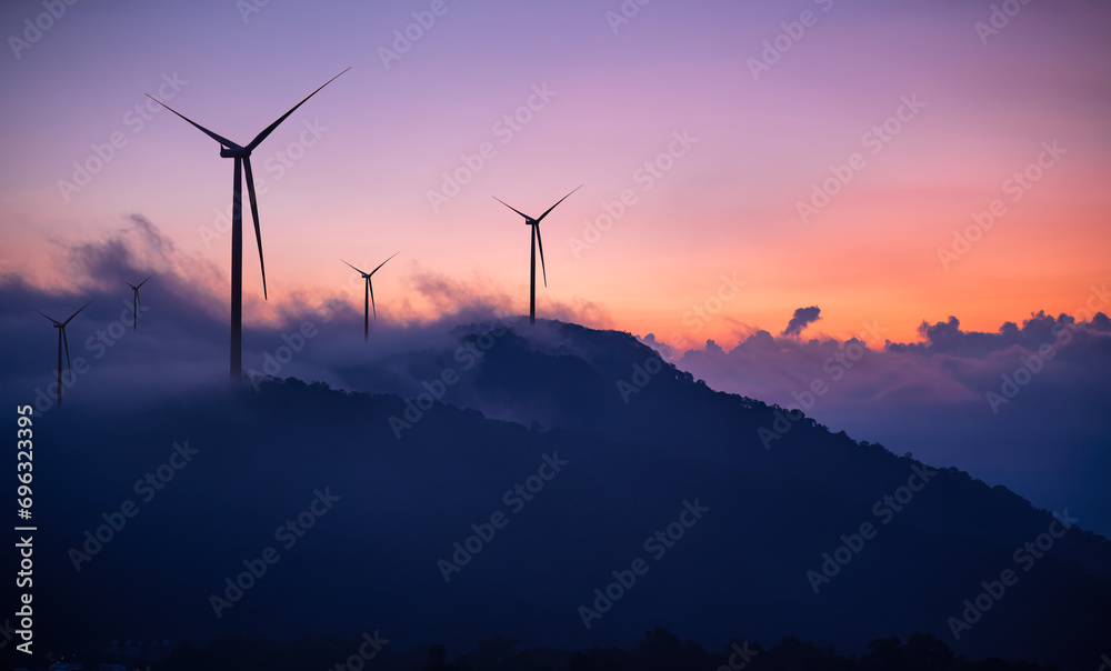 Silhouette windmill turbine  with white foggy and twilight sky background.