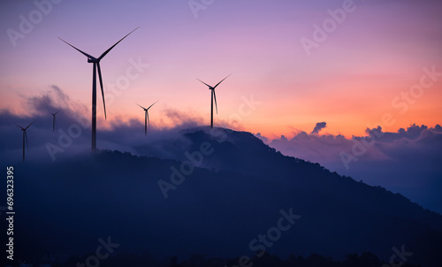 Silhouette windmill turbine  with white foggy and twilight sky background. photo