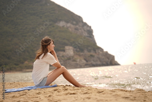 Unrecognizable woman on beach in cloudy day. Serenity, tranquility, solitude, reflection concept