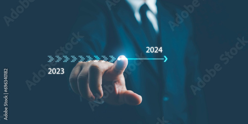 2024,Businessman touch on virtual bar status to change from 2023 to 2024, countdown of merry Christmas and happy new year by technology concept, start up on new years. start new business and new life photo