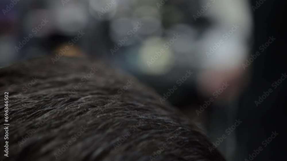 Stylish and fashionable haircut for a brunette man in a barbershop, close-up. Slow motion, professional