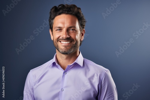 A smiling man in a purple shirt