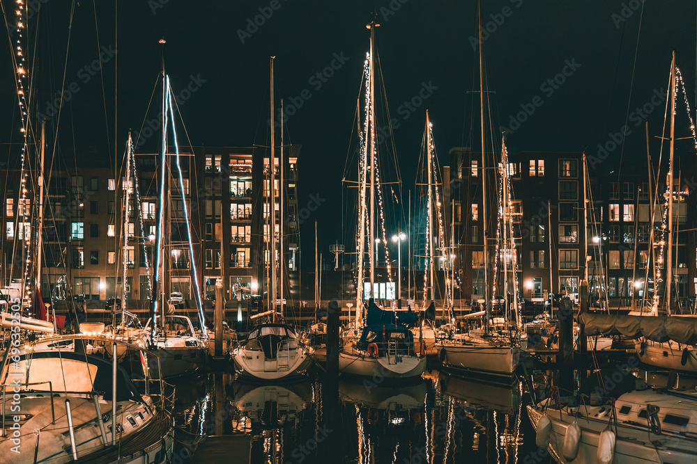 Obraz na płótnie The Hague, Netherlands - January 1, 2020: Scenic panorama of Scheveningen harbour. Romantic modern seaside resort. Brown brick buildings, light windows, moored white yachts and sailboats in evening. w salonie