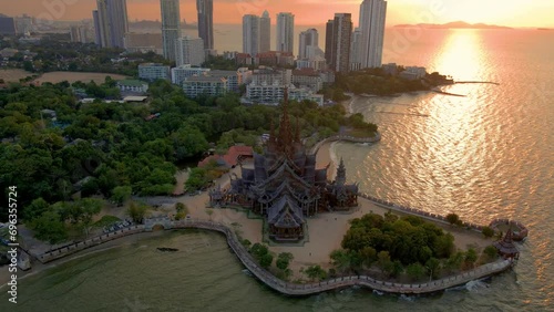 The Sanctuary of Truth wooden temple in Pattaya Thailand is a gigantic wood construction located at the cape of Naklua Pattaya City. sCity skyline of Pattay during sunset photo