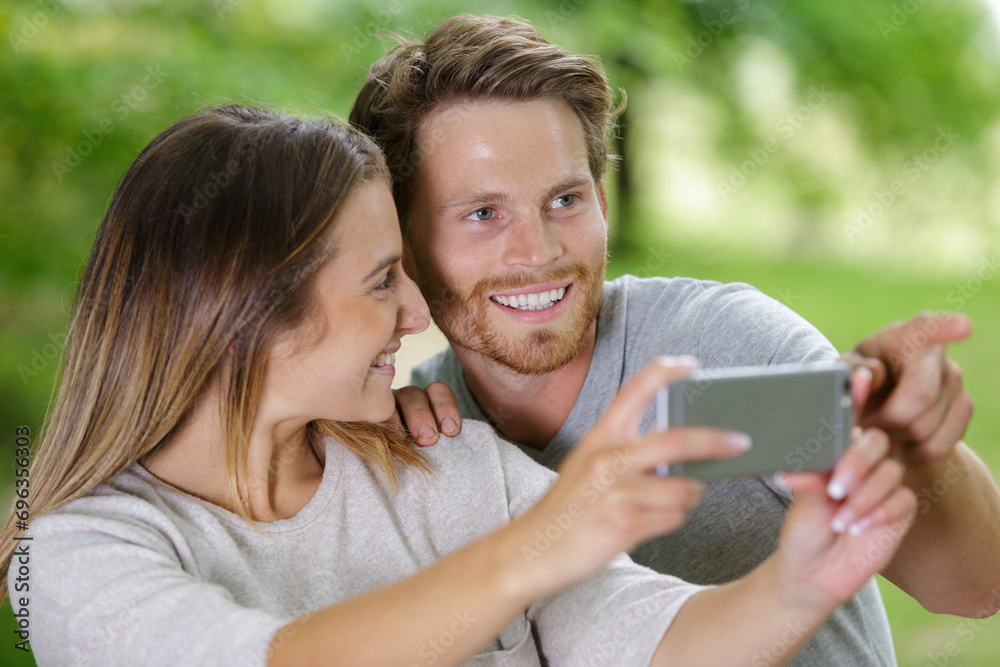 young loving couple taking selfie with smartphone in summer young loving couple taking selfie with smartphone in summer