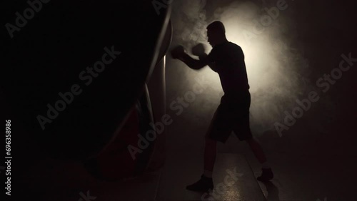 Boxer training in the gym hitting a punching bag with gloves. moment of impact on punching bag. photo