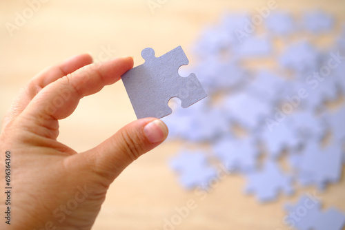 cardboard puzzle piece in female hand, concept puzzle assembly on psychological well-being, relaxation and mood enhancement