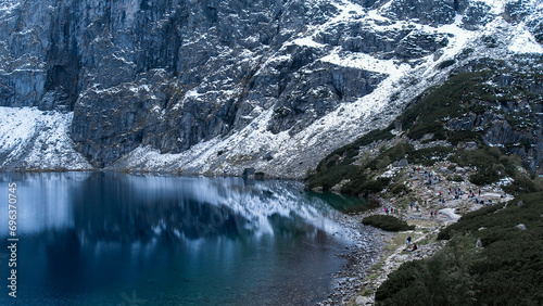 Czarny Staw pod Rysamy or Black Pond lake near the Morskie Oko Snowy Mountain Hut in Polish Tatry mountains, drone view, Zakopane, Poland. Aerial view shot of beautiful green hills and mountains in