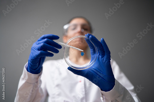 bottom view of scientist holding petri dish and examine the biological sample, health research