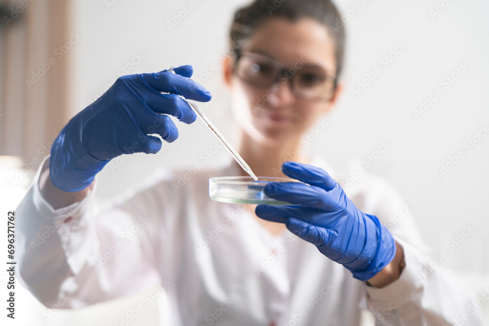 person in white uniform hold petri dish with bio samples person in white uniform hold petri dish with bio samples