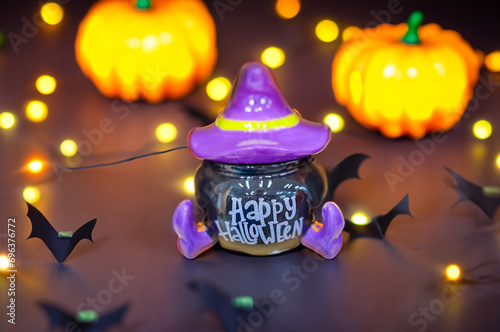 Black pumpkin with purple cap and boots for Halloween on black background photo