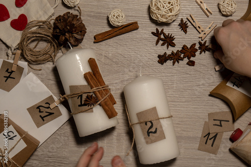 Unrecognizable young woman paint numbers on candles. Female making homemade advent calendar Made with your own hands step by step DIY crafts do it yourself. Preparation to christmas concept. Seasonal