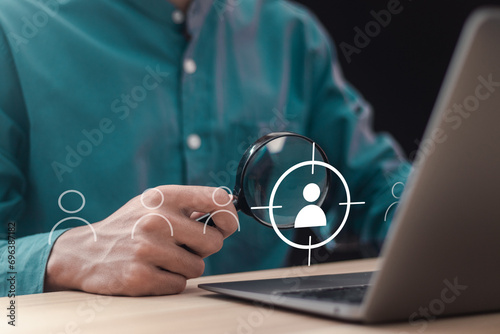 Customer Relationship Management. Businessman use magnifying glass focus target customer icon on vuital screen for customer centric strategies. Target customer, Marketing plan and strategies.