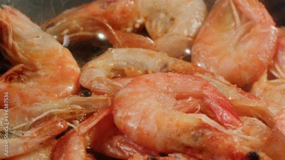 Chef cooking shrimps with oil on wok frying pan close-up. Prawns on fire throwing them on pan. Restaurant Food concept. Sea food. Chef cooking shrimps with oil on wok frying pan close-up. Prawns on fire throwing them on pan. Restaurant Food concept. Sea food.