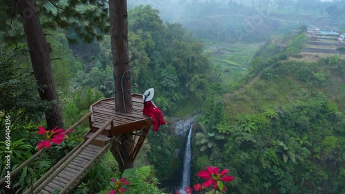 Female tourist at the viewpoint of Air Terjun Kedung Kayang Waterfall, Indonesia. photo
