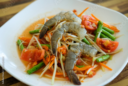 Som Tum, Thai papaya salad with raw shrimp served on plate.