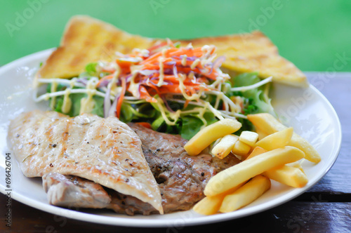 pork steak and chicken steak with French fries ,bread and salad or grilled pork and grilled chicken with fried potato